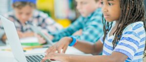 flicka student skriver på bärbar dator i klassrummet