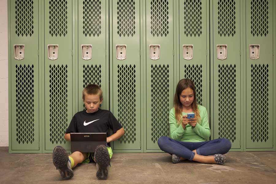 Två studenter sitter i skolans korridor