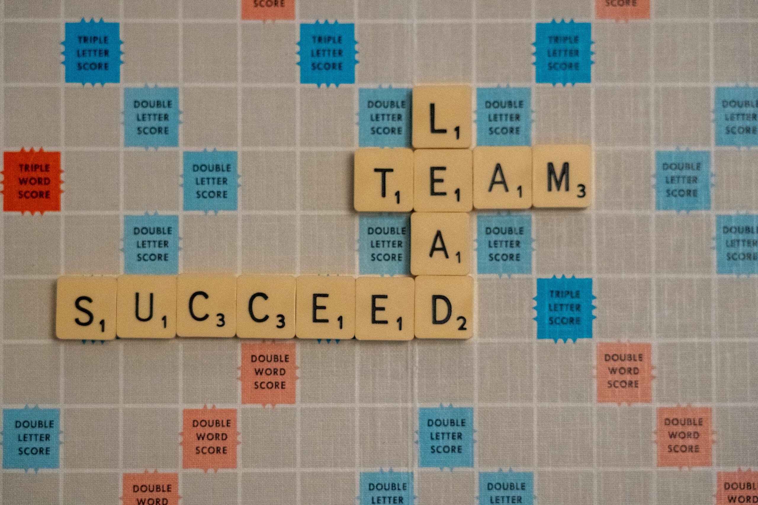 Scrabble game board with the words, "lead," Team," and "Succeed." Leadership Principles for K-12 Education.