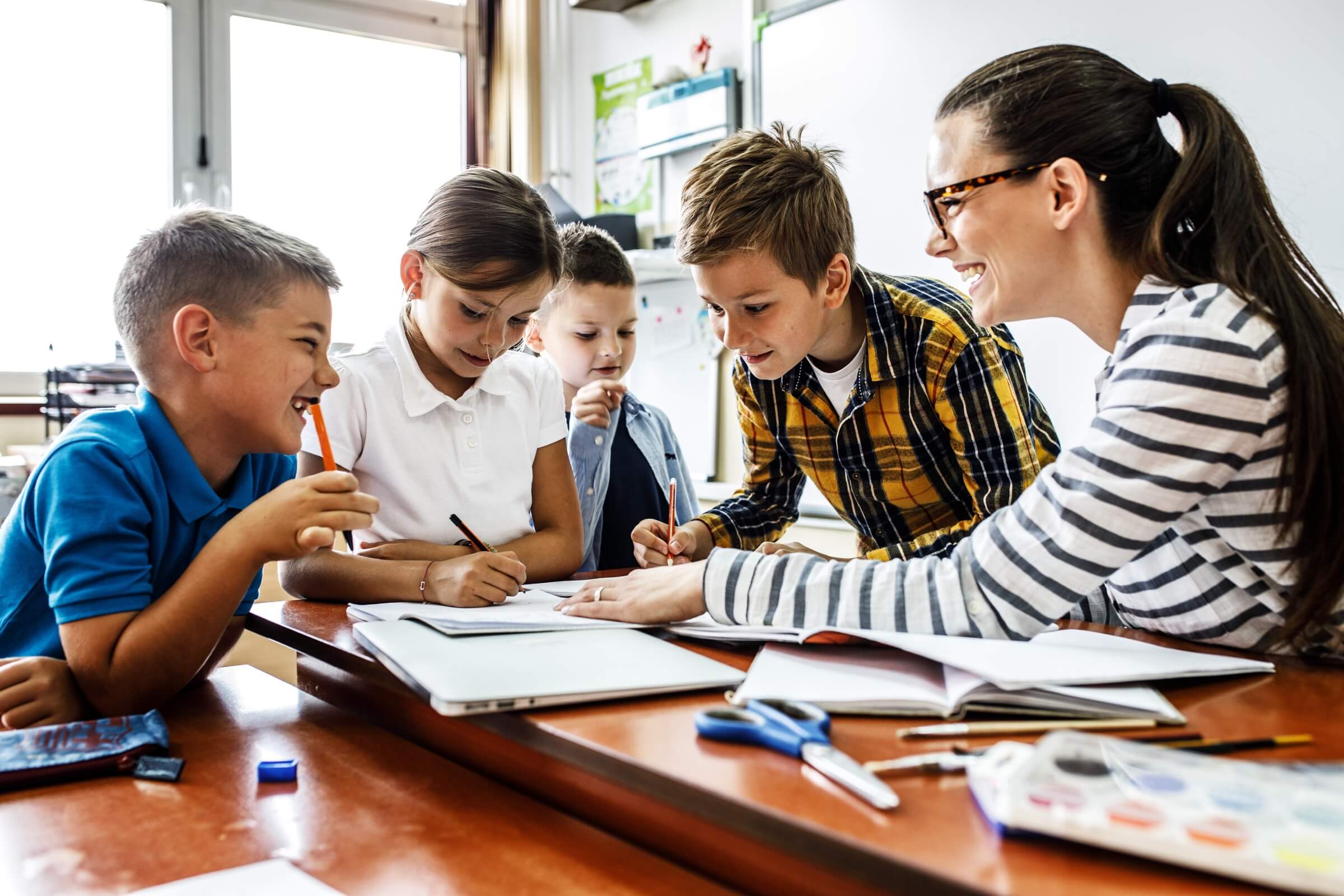 Image of teacher and elementary students collaborating in the classroom