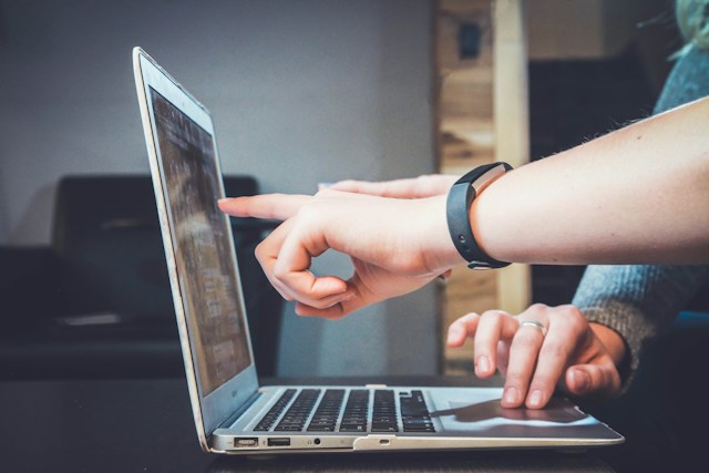 Image of Laptop with hands on keyboard and fingers pointing at screen